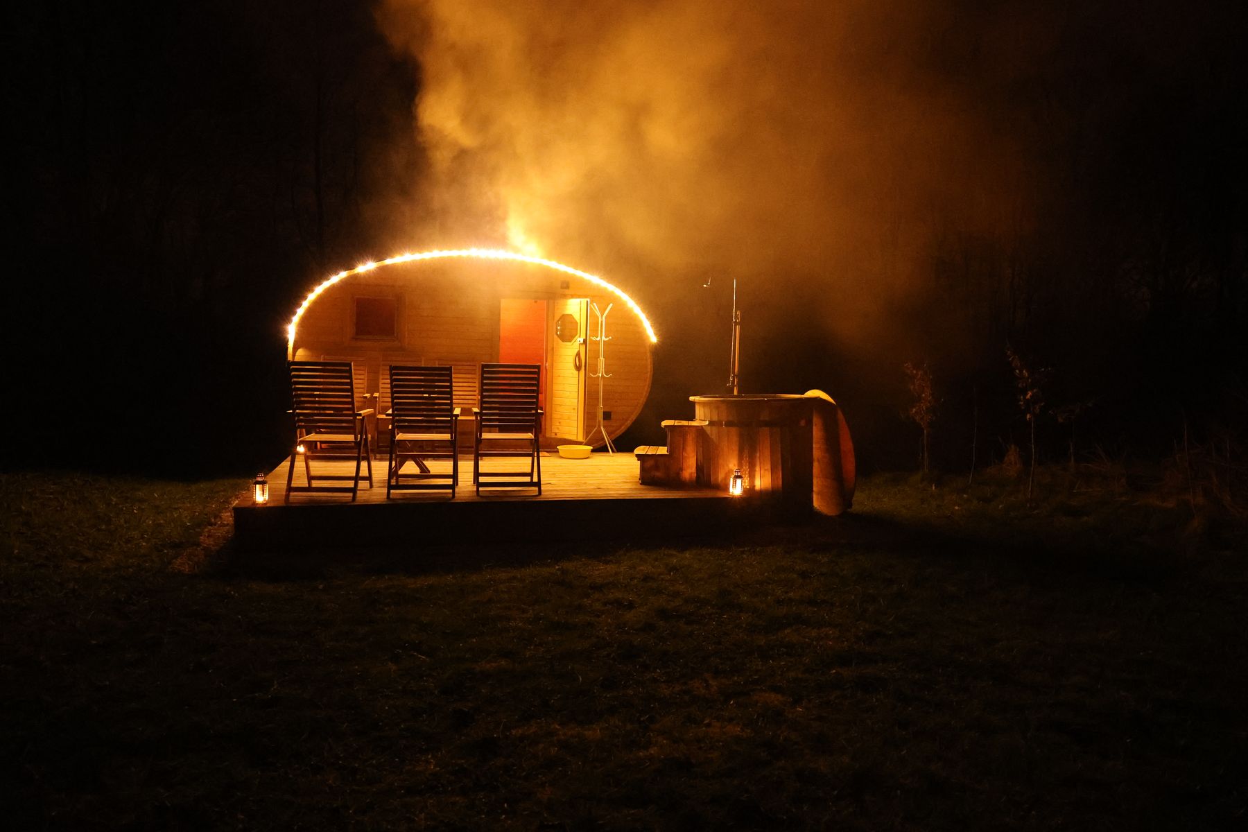 Sauna v Červeněvsi večer, osvetlená svetielkami, s terasou a kaďou